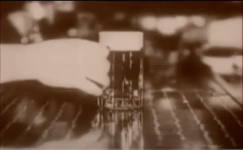 A woman's hand holding a mug of beer on a counter in a vintage speakeasy.