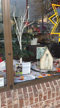 A model cottage in the window of Truth + Alibi.